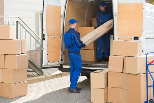 Professional furniture movers handling items in a storage unit in Wimbledon